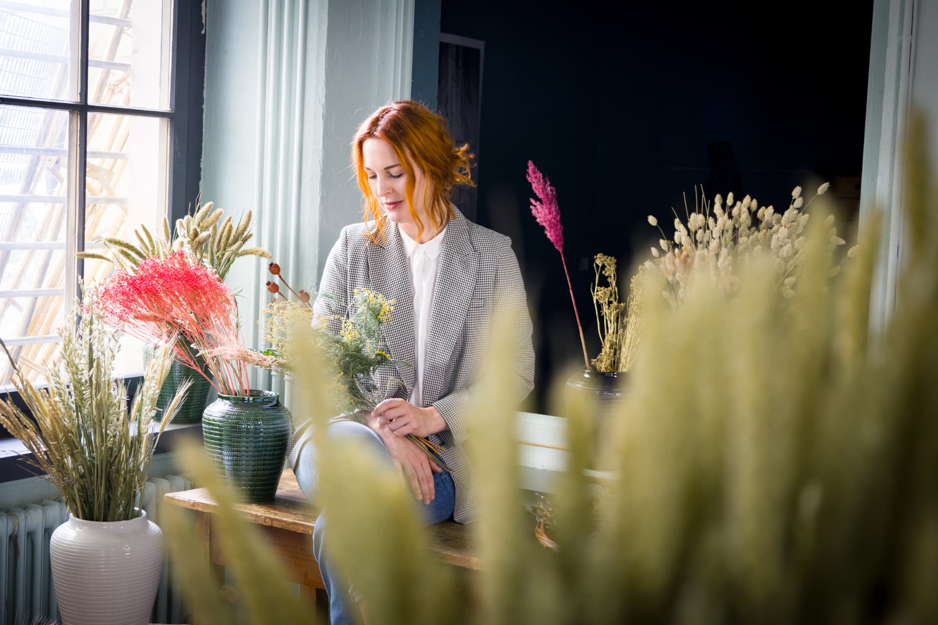 Stefanie Pitzinger, Gründerin von Holistic Botanicals, mit getrockneten Blumen in ihrer Werkstatt