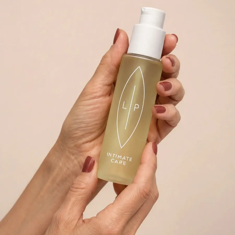 LIP Intimöl in geöffneten Händen — aktuelle Flasche mit weisser Pumpe